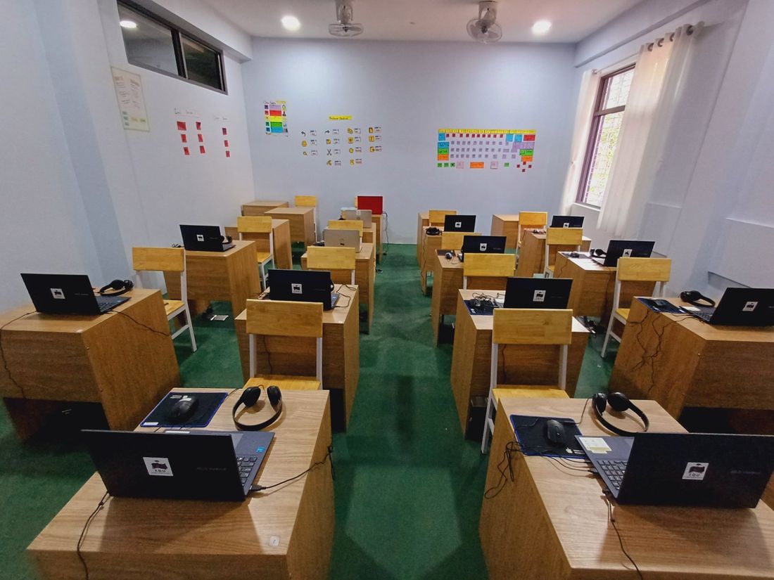 Computer lab with a laptop and headset at every desk